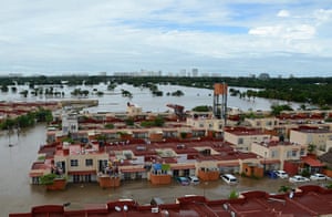 mexico floods: People stand on the rooftop of a home in a flooded neighborhood