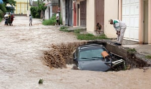 mexico floods: A man looks at his car trapped in floodwaters in Chailpanchingo