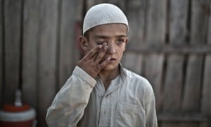 Wali Mohammed, 10, who was displaced with his family from Pakistan's tribal region of Mohmand Agency due to fighting between the Taliban and the army, wipes the dust off his eye while standing by a food vendor on the outskirts of Islamabad.