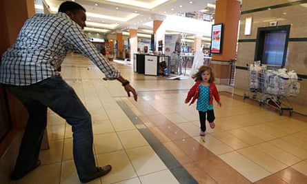 A child runs towards Abdul Yusuf Haji amid a shooting spree at Westgate shopping centre in Nairobi