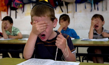 Ultra-Orthodox students gesture as they pray during a reading class
