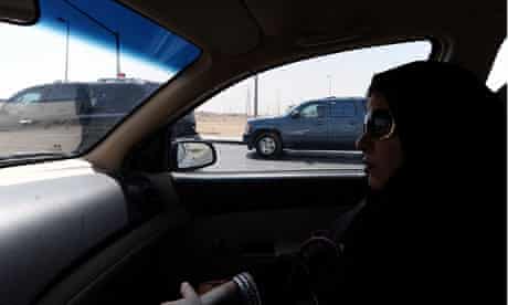 A Saudi Arabian woman sits in a vehicle as a passenger