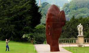 A visitor takes a photo of Marianna by Jaume Plensa, one of about 20 sculptures installed in the gardens at Chatsworth House in Derbyshire for an eight-week exhibition called Beyond Limits, curated by Sotheby's.