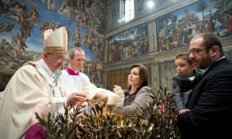 Pope Francis baptises a child in the Sistine Chapel in Rome