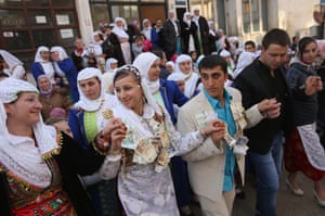 The bride and her groom, participate in a group dance with money pinned to their clothes received from friends and relatives.