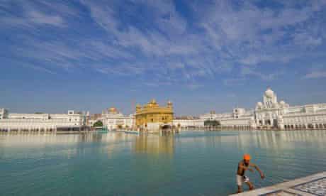 A Sikh pilgrim bathes in the sarovar of the Golden Temple of Amritsar, India