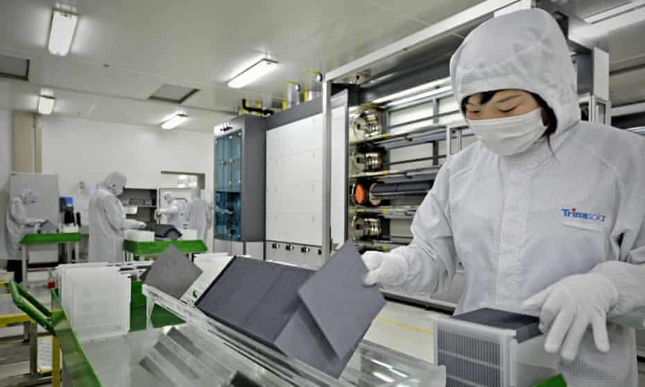 A masked lab worker sorts silicon wafers at the manufacturing centre of solar cells, Changzho, China.