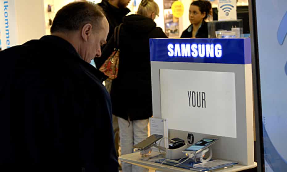 A man looks at a Samsung smartphone in a store. The company is looking to boost sales of its top-end devices.