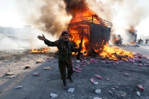 Weekend in pictures: Aleppo, Syria: A Free Syrian Army fighter reacts to a vehicle on fire after