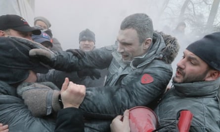 Opposition leader and former WBC heavyweight boxing champion Vitali Klitschko, center, is attacked and sprayed with a fire extinguisher as he tries to stop the clashes between police and protesters  in central Kiev, Ukraine.