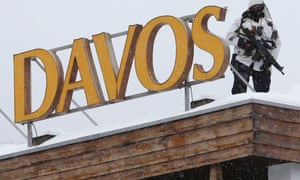 A Swiss special policeman patrols on a roof before the start of the annual meeting of the World Economic Forum 2014 in Davos.
