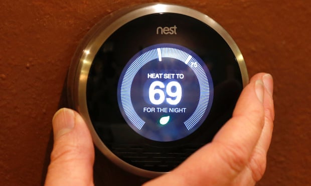 A Nest thermostat being adjusted in a home.