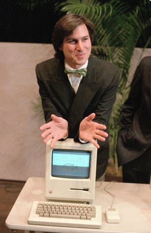 Steve Jobs poses with 1984's Macintosh computer following a shareholder's meeting