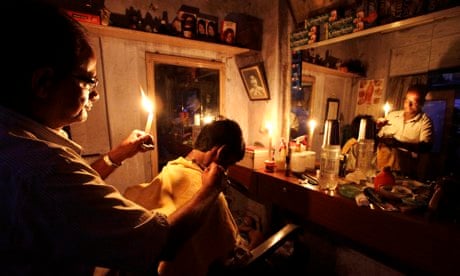 A barber in Kolkata gives a customer a haircut during the Indian blackout of 2012