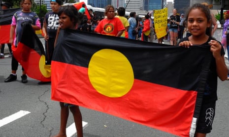 Children carrying the Australian Aboriginal Flag in Brisbane on Australia day.