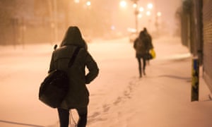 People make their way through snow-covered streets in Brooklyn, New York.