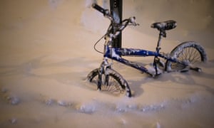A bicycle is buried by overnight snowfall in the Queens area of New York.