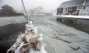 Houses line a flooded street along the shore in Scituate, Massachusetts