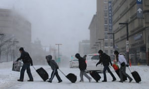Travellers leave the Back Bay train and subway station during the storm in Boston, Massachusetts