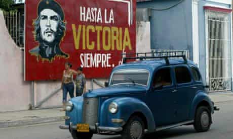 A vintage car passes a Che Guevara mural in Cuba