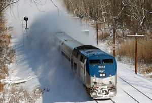 An Amtrak train kicks up fresh snow as it speeds along the tracks in Schodack Landing, New York. 