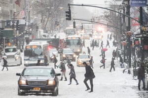 Traffic and pedestrians brave icy conditions on Fifth Avenue, in New York City.