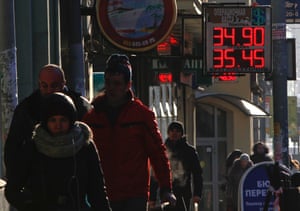 People walk past a currency exchange board showing rouble exchange rates in Moscow January 30, 2014