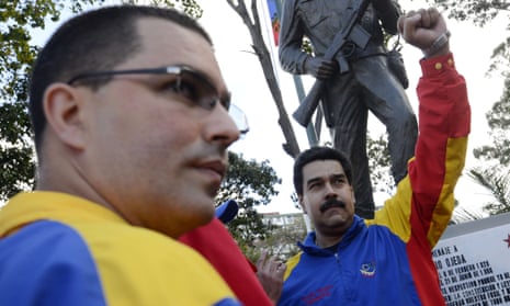 Venezuelan President Nicolas Maduro raises his fist next to vice-president Jorge Arreaza, during a rally.