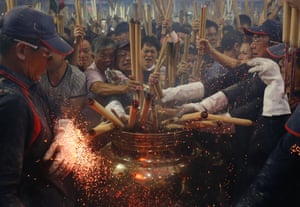 On the stroke of midnight people rush to be first to put their joss stick in the ceremonial pot at a temple in Singapore, marking the beginning of the Chinese New Year.