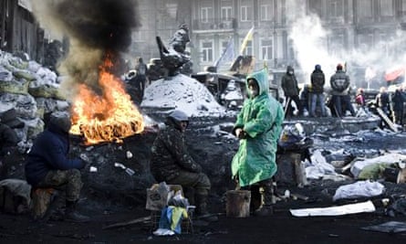 Ukrainian protesters warm up themselves on the barricade during ongoing protests in Kiev, Ukraine. P