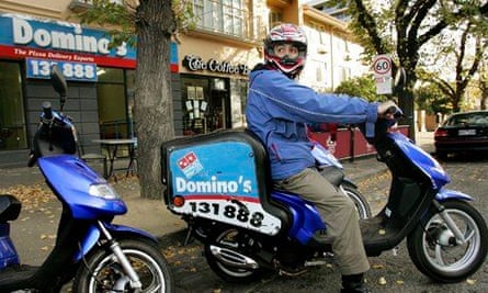 A Domino's Pizza delivery boy prepares t