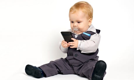 blond baby in suit texting with mobile phone
