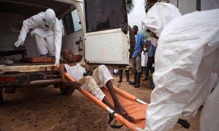 Healthcare workers load a man suspected of suffering from the Ebola virus onto an ambulance in Kenema, Sierra Leone.