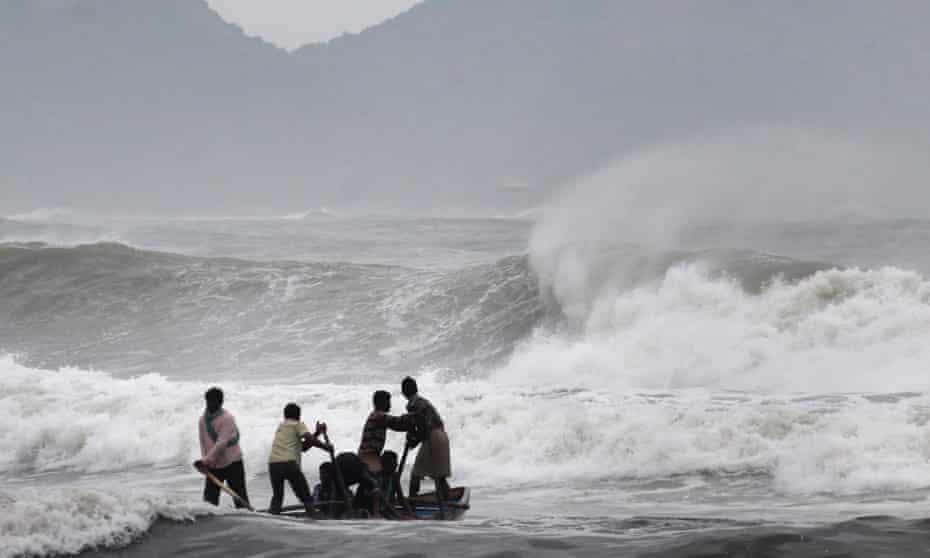 Indian fishermen negotiate their skiff through rough waves ahead of cyclone Hudhud.