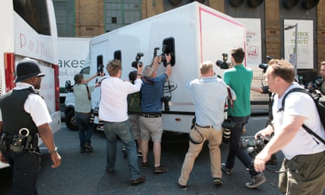 Photographers chase Rolf Harris' prison van as it leaves Southwark crown court.