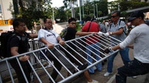 Pro-democracy demonstrators, left, scuffle with anti-occupy protesters, right, as they grab a metal fence at the main protest site.