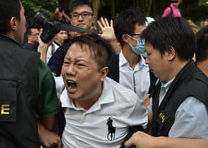 Police officers arrest an anti-occupy protester.