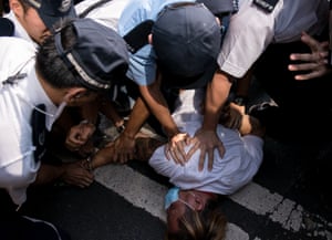 Police detain a man who had attacked pro-democracy demonstrators.
