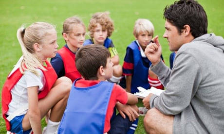 Football coach talking to his young team 