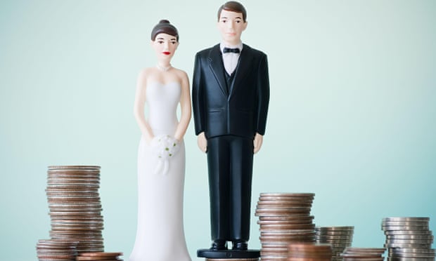 Wedding cake figurines on stacks of coins