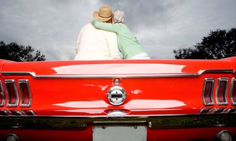 A senior couple in a sports car