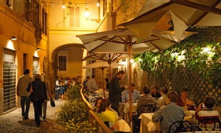 People sitting on a restaurant terrace in Trastevere, Rome.