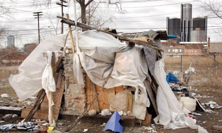 The GM headquarters building looms behind a homeless shanty in Detroit, Michigan