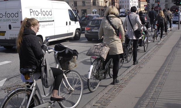 Cyclists in Copenhagen queue patiently for traffic lights – better design leads to better behaviour.