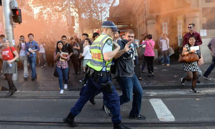 A protester is arrested during a march through the central business district in Sydney.