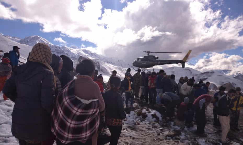 People gather near a Nepal army helicopter being used to rescue avalanche victims in the Annapurna region.
