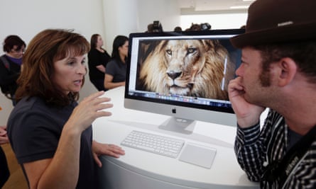 An apple employee, at left, explains the features of the new iMac at Apple headquarters on Thursday, Oct. 16, 2014 in Cupertino, California.