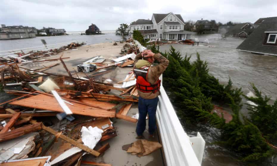 In this Oct. 30, 2012 file photo, Brian Hajeski, 41, of Brick, N.J., reacts as he looks at debris of a home that washed up on to the Mantoloking Bridge the morning after superstorm Sandy rolled through in Mantoloking, N.J. S