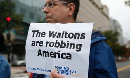 Holding a sign, a man joins Walmart employees and supporters as they block off a major intersection near the Walton Family Foundation in downtown Washington October 16, 2014.
