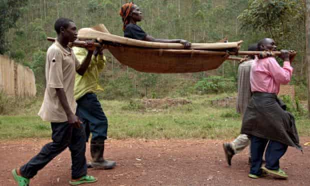 An HIV-positive Congolese woman is carried to hospital on a stretcher